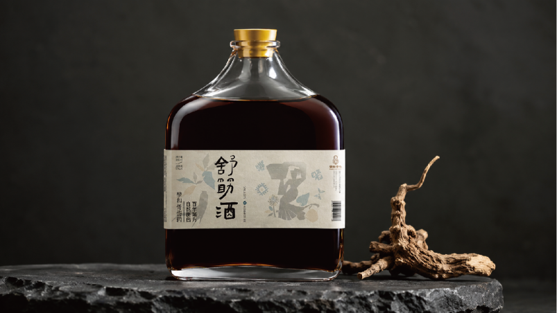 深色背景中陈列的壁和舒筋酒玻璃瓶与中药材根茎